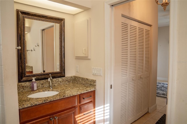 bathroom with tile patterned flooring, a closet, vanity, and baseboards