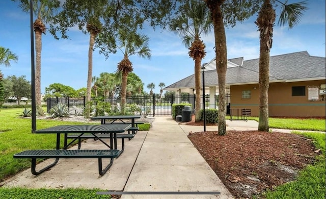 view of community featuring a yard, a patio area, and fence