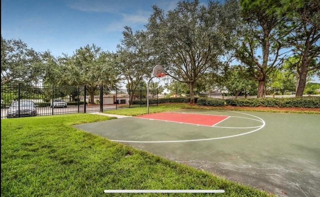 view of basketball court featuring community basketball court, fence, and a lawn