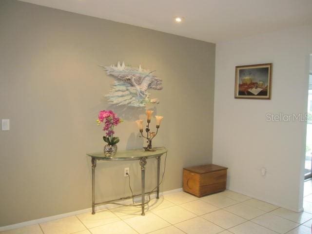 corridor with light tile patterned floors, baseboards, and recessed lighting