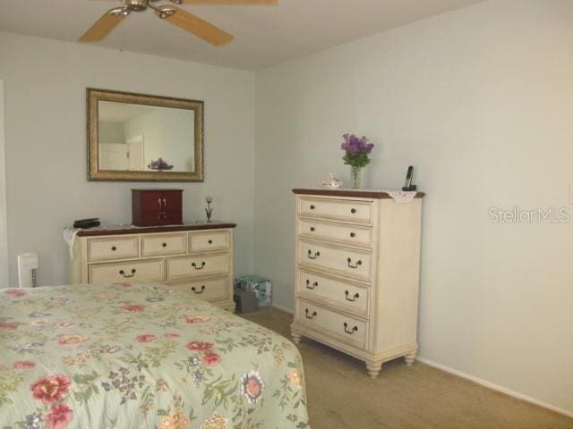 bedroom featuring baseboards, a ceiling fan, and light colored carpet