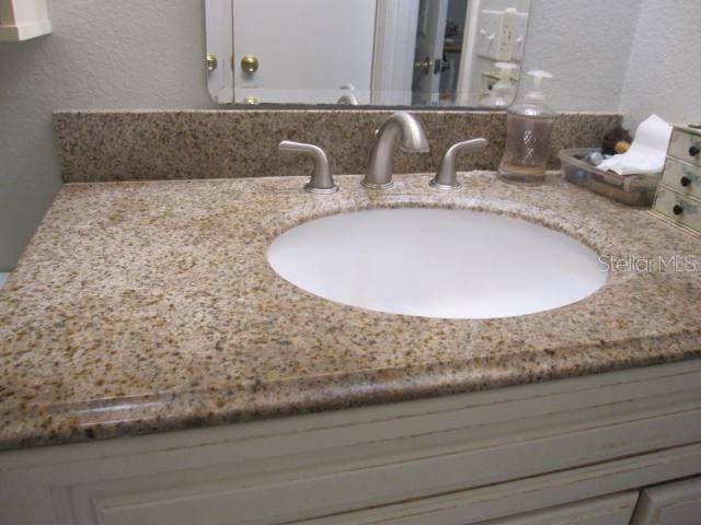 interior details with a textured wall and vanity