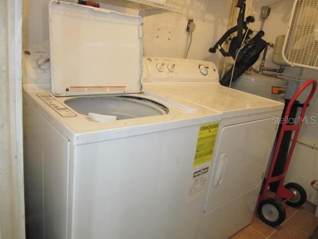 clothes washing area with laundry area, separate washer and dryer, and tile patterned floors