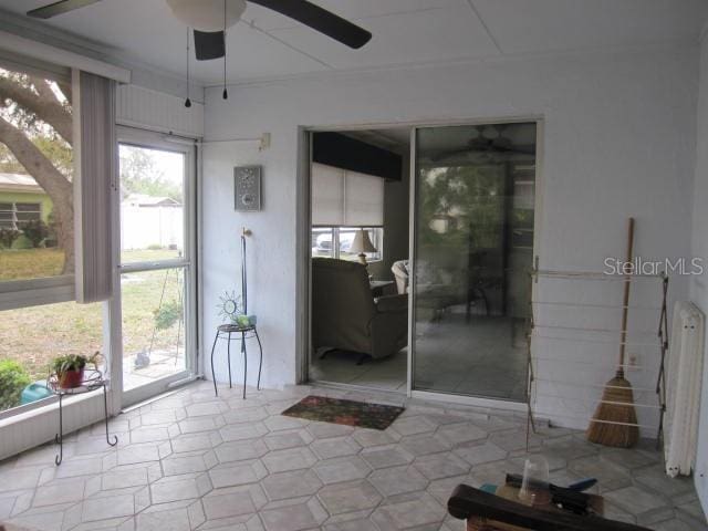 unfurnished sunroom with a ceiling fan