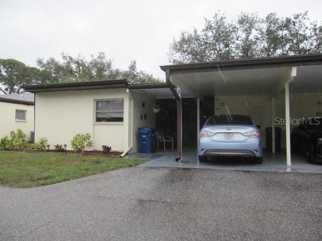 view of parking / parking lot with an attached carport and driveway