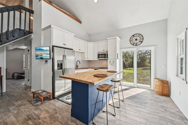 7415 36th Ave E, Palmetto, FL 34221 - kitchen with wood counters, a kitchen bar, white cabinetry, and appliances with stainless steel finishes