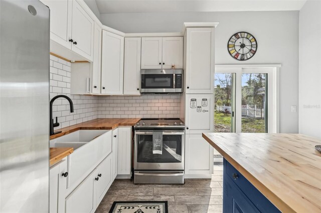 7415 36th Ave E, Palmetto, FL 34221 - kitchen with appliances with stainless steel finishes, blue cabinets, white cabinetry, sink, and wooden counters