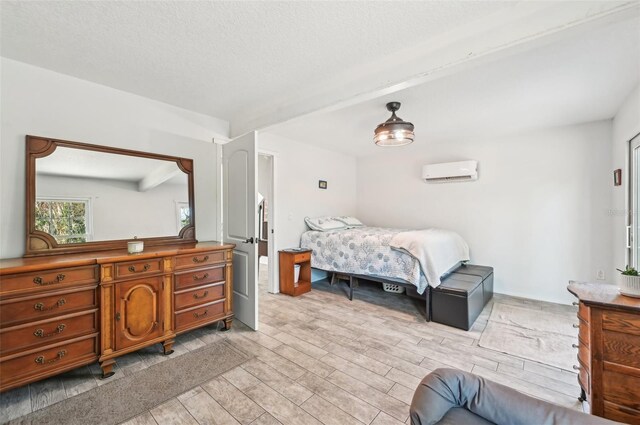 7415 36th Ave E, Palmetto, FL 34221 - bedroom featuring beamed ceiling, a wall mounted air conditioner, a textured ceiling, and light hardwood / wood-style flooring