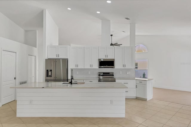 kitchen featuring sink, ceiling fan, appliances with stainless steel finishes, white cabinetry, and a kitchen island with sink