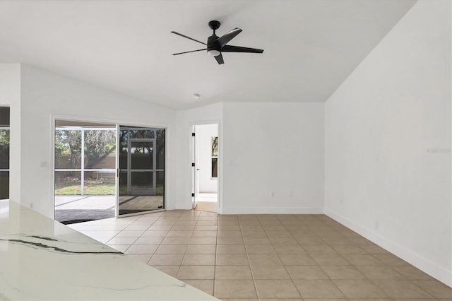 tiled spare room featuring ceiling fan and vaulted ceiling