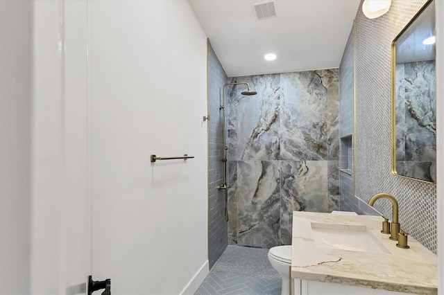 bathroom featuring walk in shower, vanity, toilet, and tile walls