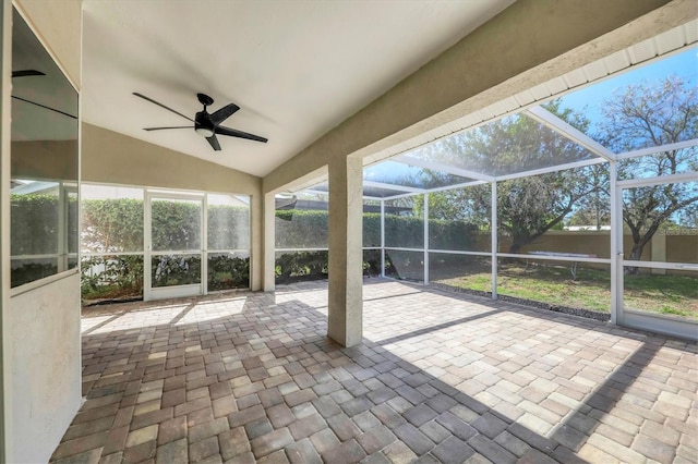 unfurnished sunroom with ceiling fan and vaulted ceiling