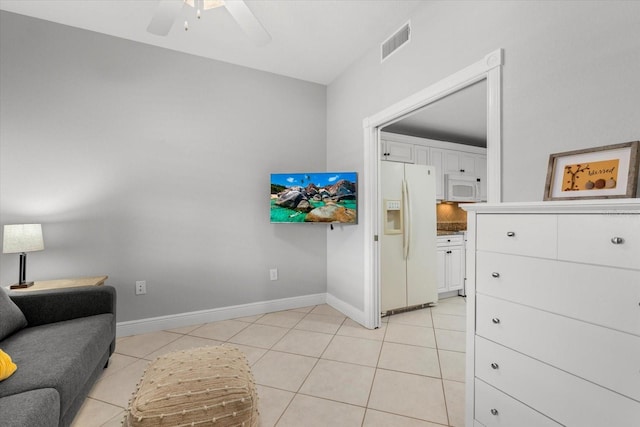 interior space featuring visible vents, ceiling fan, baseboards, and light tile patterned flooring