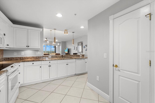 kitchen with white appliances, white cabinets, a sink, and decorative light fixtures