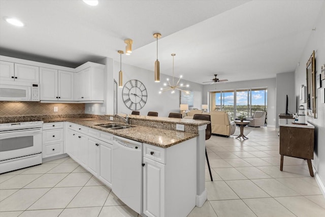 kitchen with white appliances, white cabinets, a sink, and a peninsula