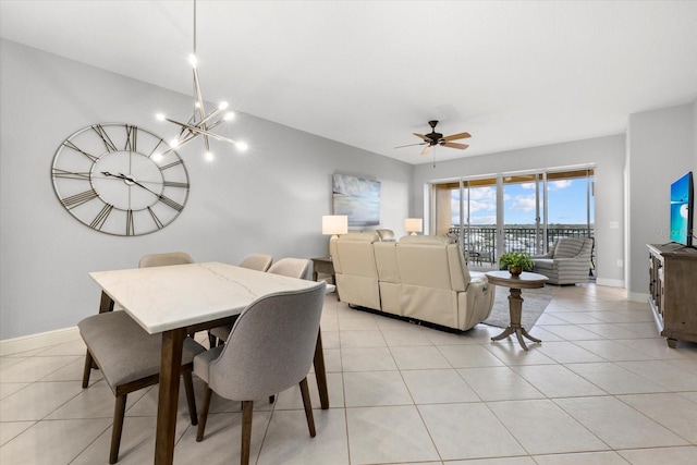 dining room featuring ceiling fan with notable chandelier, light tile patterned flooring, and baseboards
