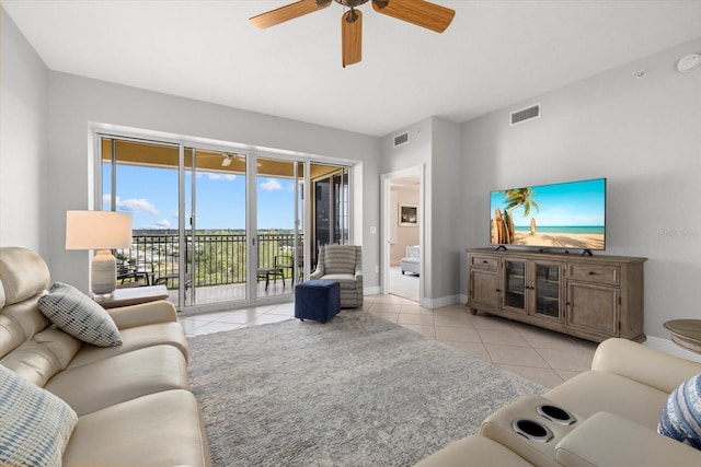 living area featuring a ceiling fan, visible vents, baseboards, and light tile patterned floors