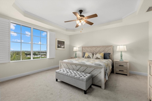 bedroom with baseboards, a tray ceiling, ornamental molding, and light colored carpet