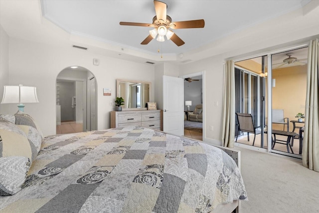 bedroom featuring arched walkways, a raised ceiling, visible vents, light carpet, and access to outside