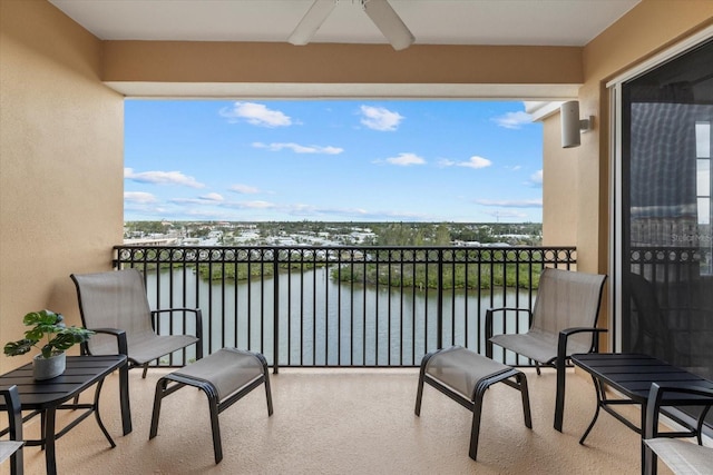 balcony featuring ceiling fan and a water view