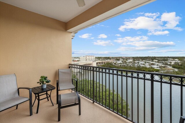 balcony featuring a water view and ceiling fan