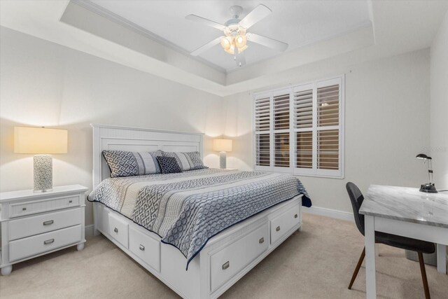 147 Tampa Ave E Unit 702, Venice, FL 34285 - bedroom with a tray ceiling, light carpet, crown molding, baseboards, and a ceiling fan