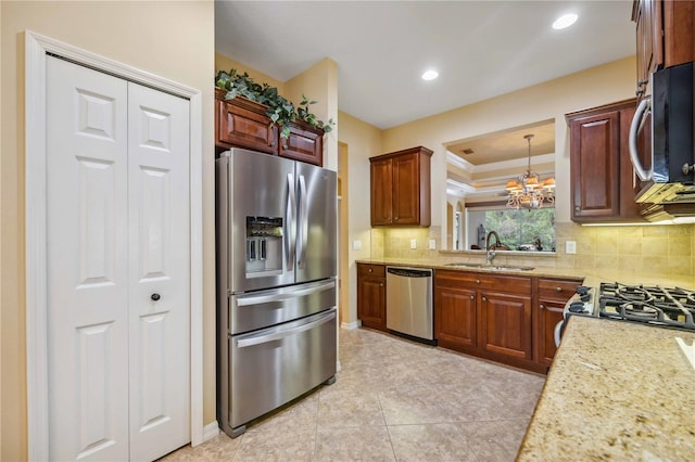 kitchen with a chandelier, recessed lighting, stainless steel appliances, a sink, and tasteful backsplash