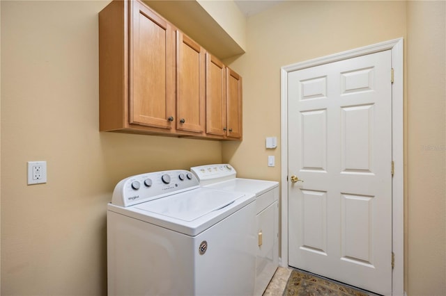 clothes washing area featuring cabinet space and washer and dryer