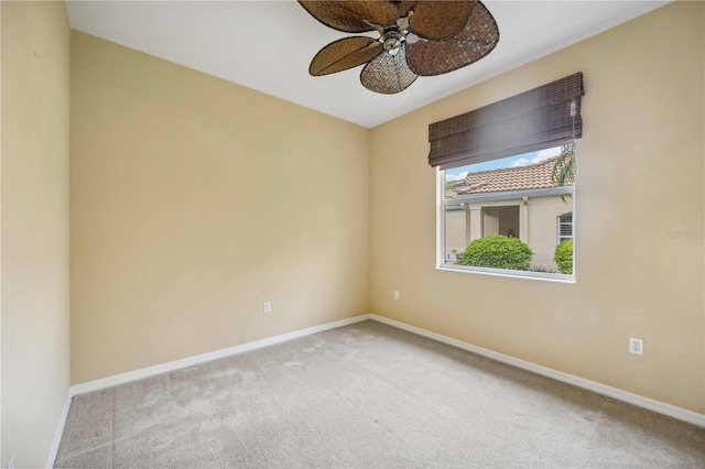 spare room with carpet, a ceiling fan, and baseboards