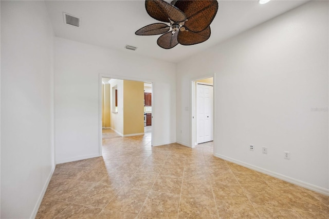 spare room featuring light tile patterned floors, baseboards, visible vents, and a ceiling fan