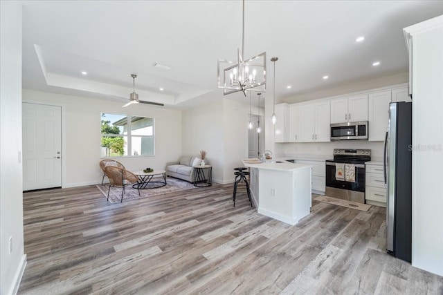 18290 Grace Ave, Port Charlotte, FL 33948 - kitchen with appliances with stainless steel finishes, open floor plan, light wood-style floors, a breakfast bar area, and recessed lighting