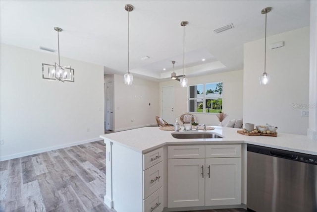 18290 Grace Ave, Port Charlotte, FL 33948 - kitchen with stainless steel dishwasher, a tray ceiling, light countertops, and open floor plan
