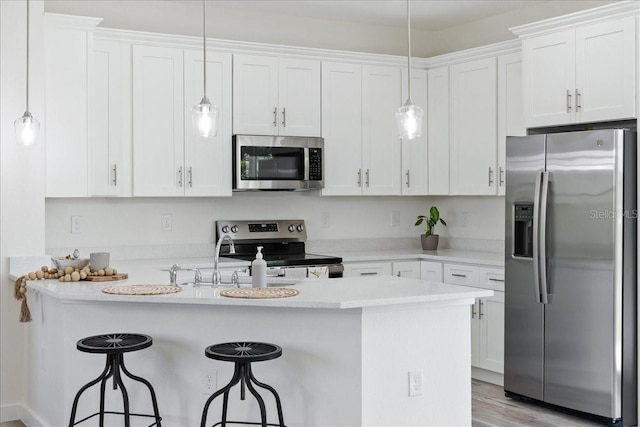 18290 Grace Ave, Port Charlotte, FL 33948 - kitchen featuring appliances with stainless steel finishes, a breakfast bar area, white cabinetry, decorative light fixtures, and light countertops