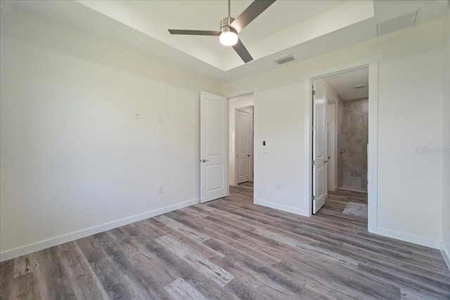 18290 Grace Ave, Port Charlotte, FL 33948 - unfurnished bedroom with wood finished floors, ceiling fan, and ensuite bathroom