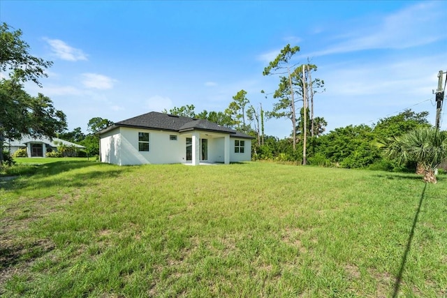 18290 Grace Ave, Port Charlotte, FL 33948 - rear view of property featuring a yard and stucco siding