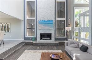 living room with dark hardwood / wood-style floors and a large fireplace