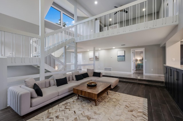 living room featuring hardwood / wood-style flooring and a towering ceiling