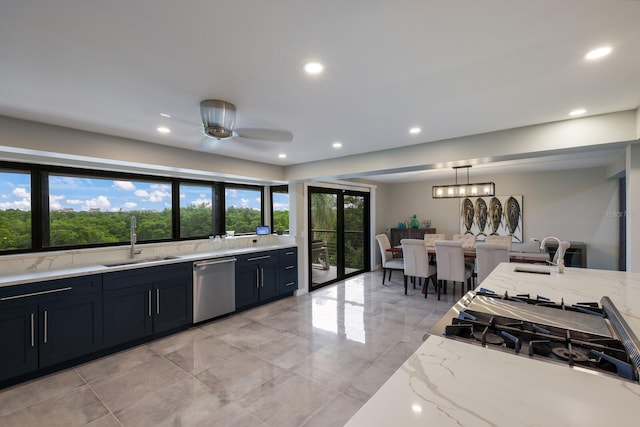 kitchen with stovetop, sink, light stone counters, stainless steel dishwasher, and pendant lighting