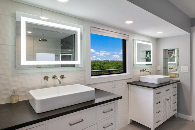 bathroom with vanity, tile walls, and a shower