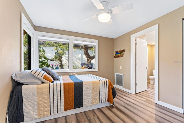 bedroom with light hardwood / wood-style floors, ceiling fan, and ensuite bathroom