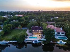 aerial view at dusk featuring a water view