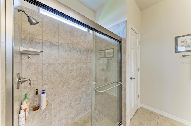 bathroom with an enclosed shower and tile patterned flooring