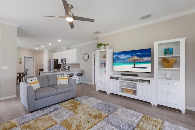 living room with ornamental molding and ceiling fan