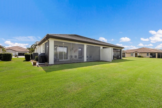 back of property with a lawn and a sunroom