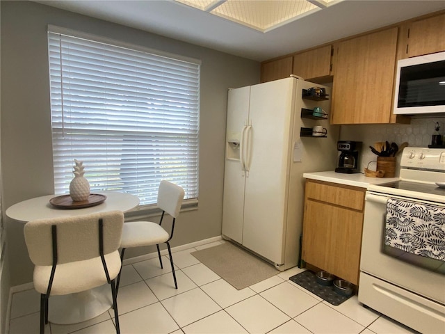 kitchen featuring backsplash, white appliances, and light tile patterned floors