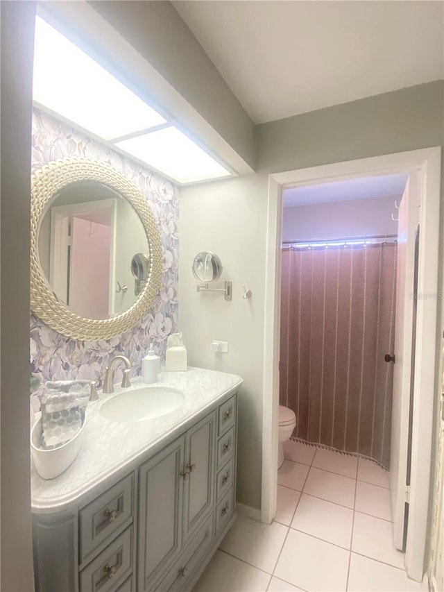 bathroom featuring toilet, vanity, and tile patterned flooring