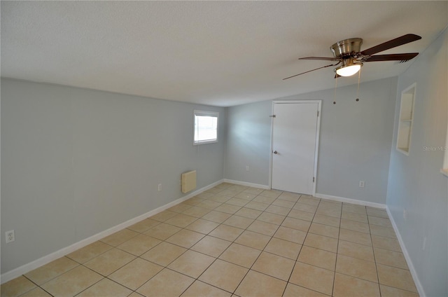 empty room featuring ceiling fan, vaulted ceiling, and a textured ceiling