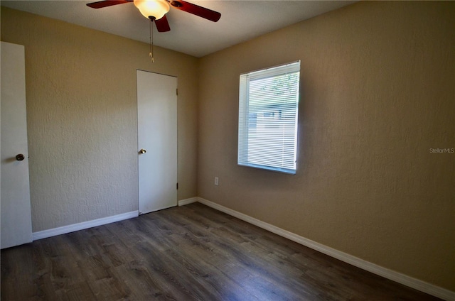 unfurnished room with dark wood-type flooring and ceiling fan