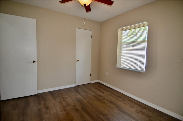 empty room with dark hardwood / wood-style flooring and ceiling fan