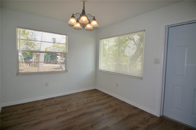 unfurnished dining area featuring dark hardwood / wood-style flooring, plenty of natural light, and a chandelier